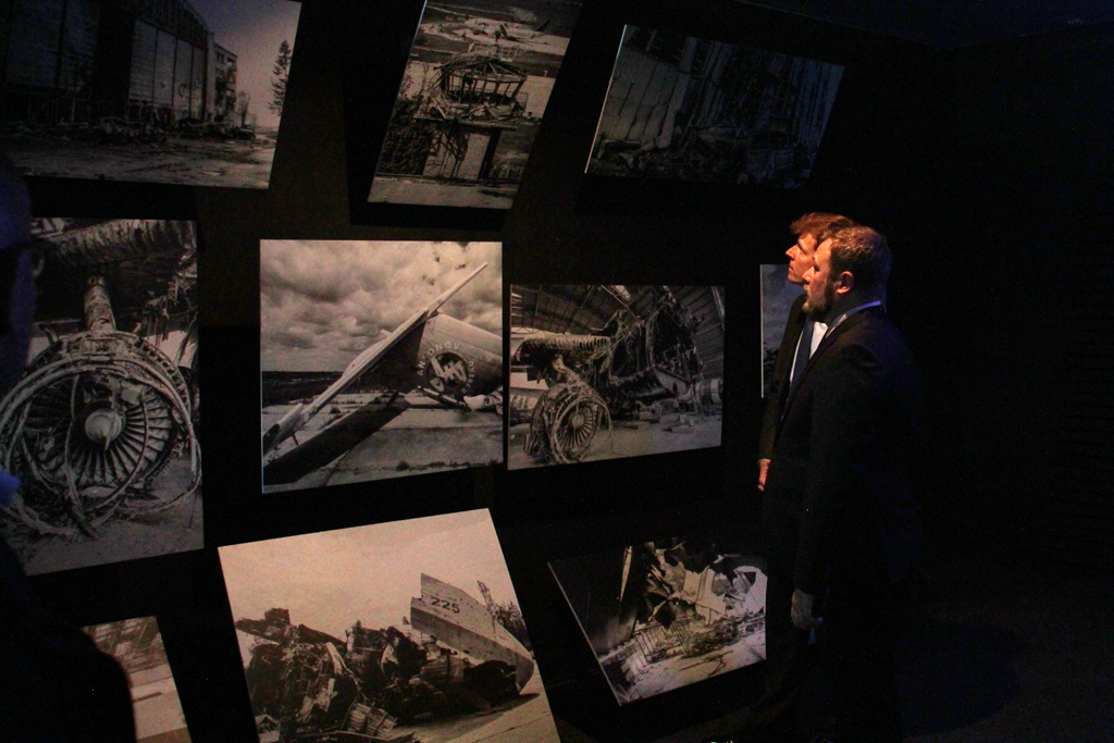 Flughafenchef Ahmelsmann und Antonov-Generaldirektor Gavrylov im dunklen Raum der Ausstellung, der die Zerstörung der AN-225 thematisiert